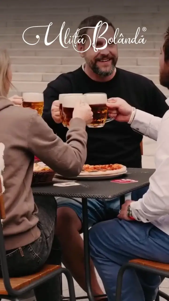 Prieteni care ciocnesc halbe de bere Svijany pe o terasă